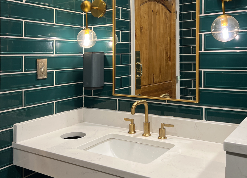 Close detail of finished tile work and brass bathroom fittings
