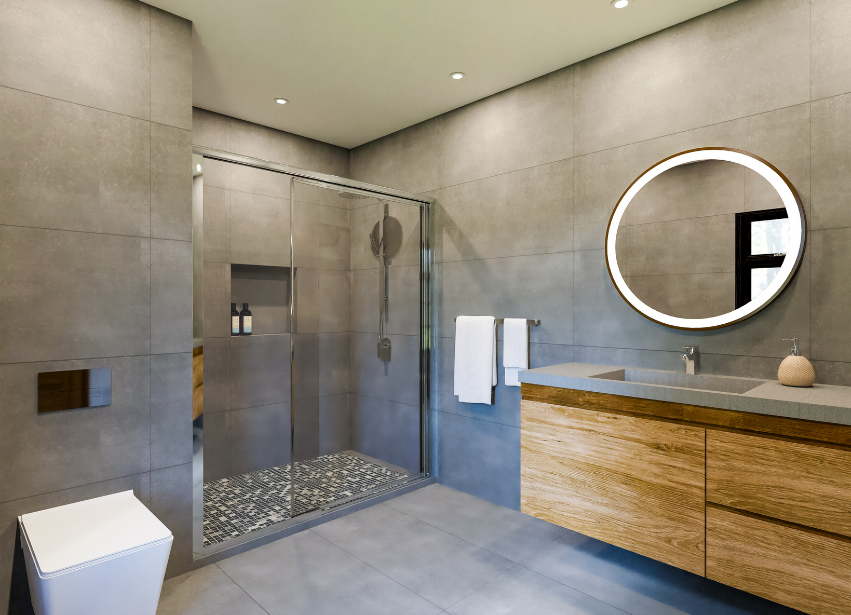 Walk in shower with large format grey tile and round lit mirror